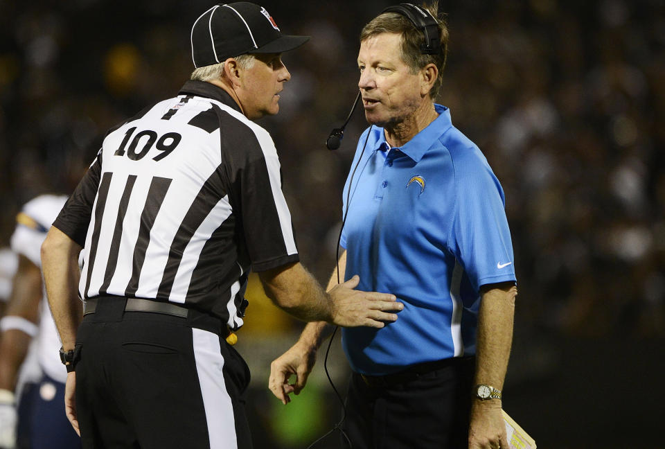 Head Coach Norv Turner (R) of the San Diego Chargers talks with an official Noal Strickland #109 while a play is under review against the Oakland Raiders during the second quarter of the season opener at Oakland-Alameda County Coliseum on September 10, 2012 in Oakland, California. (Photo by Thearon W. Henderson/Getty Images)