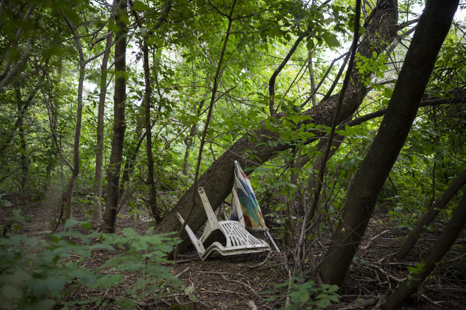 Muddy plastic chairs sit near the Tisza River near Tiszaroff, Hungary, Tuesday, Aug. 1, 2023. Life-jacketed rivergoers of all ages pile into dozens of canoes to scour Hungary’s second-largest river for trash that has flowed downstream. (AP Photo/Denes Erdos)