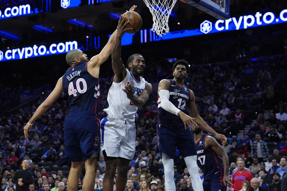 Los Angeles Clippers' Kawhi Leonard, center, goes up for a shot against Philadelphia 76ers' Tobias Harris, right, and Nicolas Batum during the second half of an NBA basketball game, Wednesday, March 27, 2024, in Philadelphia. (AP Photo/Matt Slocum)