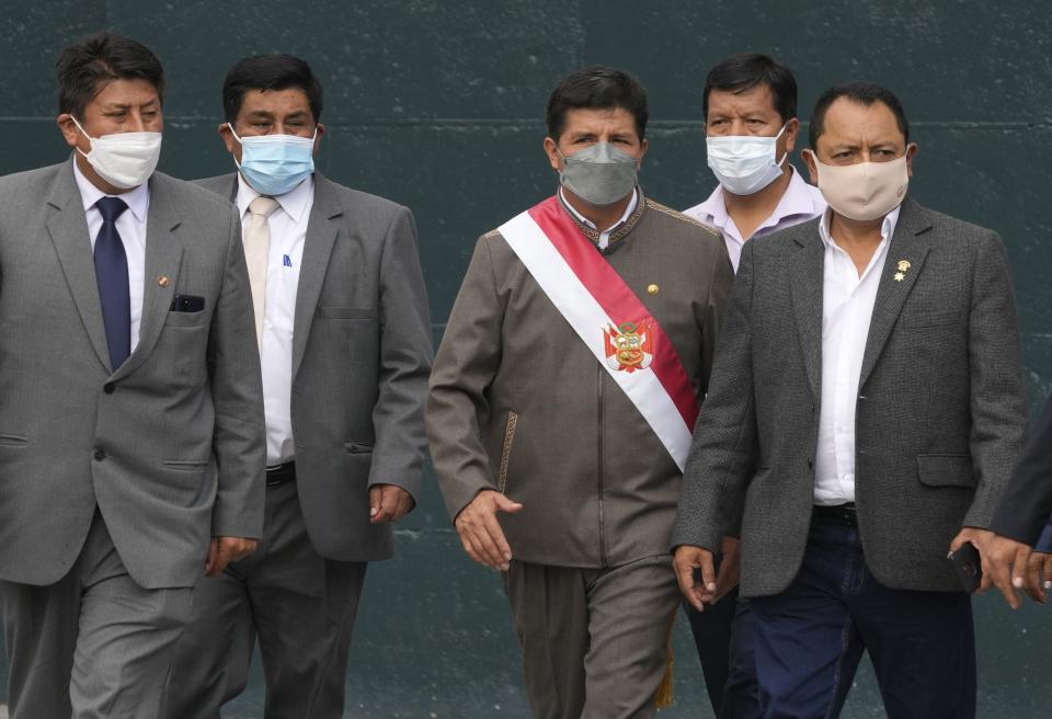 Peru's President Pedro Castillo, center, surrounded by his party´s congressmen leaves Congress where lawmakers voted to proceed with impeachment proceedings against him, in Lima, Peru, Monday, March 28, 2022. (AP Photo/Martin Mejia)