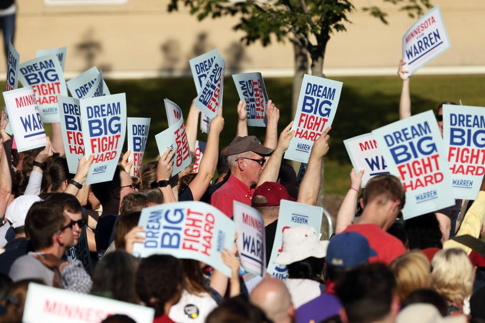 Supporters wave signs before Democratic presidential candidate Elizabeth Warren, D-Mass., speaks at a rally Monday, Aug. 19, 2019, at Macalaster College during a campaign appearance in St. Paul, Minn. (AP Photo/Jim Mone)