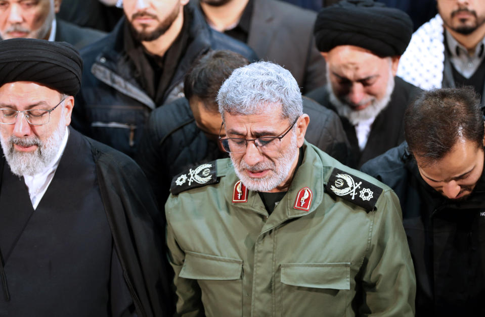 FILE - In this photo released by the official website of the Office of the Iranian Supreme Leader, Gen. Esmail Ghaani, newly appointed commander of Iran's Revolutionary Guards Quds Force, weeps while praying over the coffin of the force's previous head Gen. Qassem Soleimani at the Tehran University Campus in Tehran, Iran, Monday, Jan. 6, 2020. On Friday, Nov. 20, two Iraqi officials say Iran has instructed allies in the Middle East to be on high alert and avoid provoking tensions with the U.S. that could give an outgoing Trump Administration cause to launch attacks in his final weeks in office. (Office of the Iranian Supreme Leader via AP)