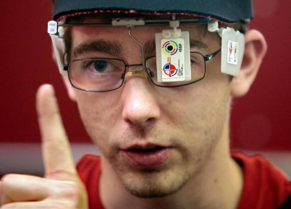 NC State rising senior Lucas Kozeniesky, 21, illustrates for reporters how his optical blinders aid in his focusing sharply on his front sight during a gear-up and air rifle practice at the NC State Rifle Team air rifle range on the NC State campus in 2016.