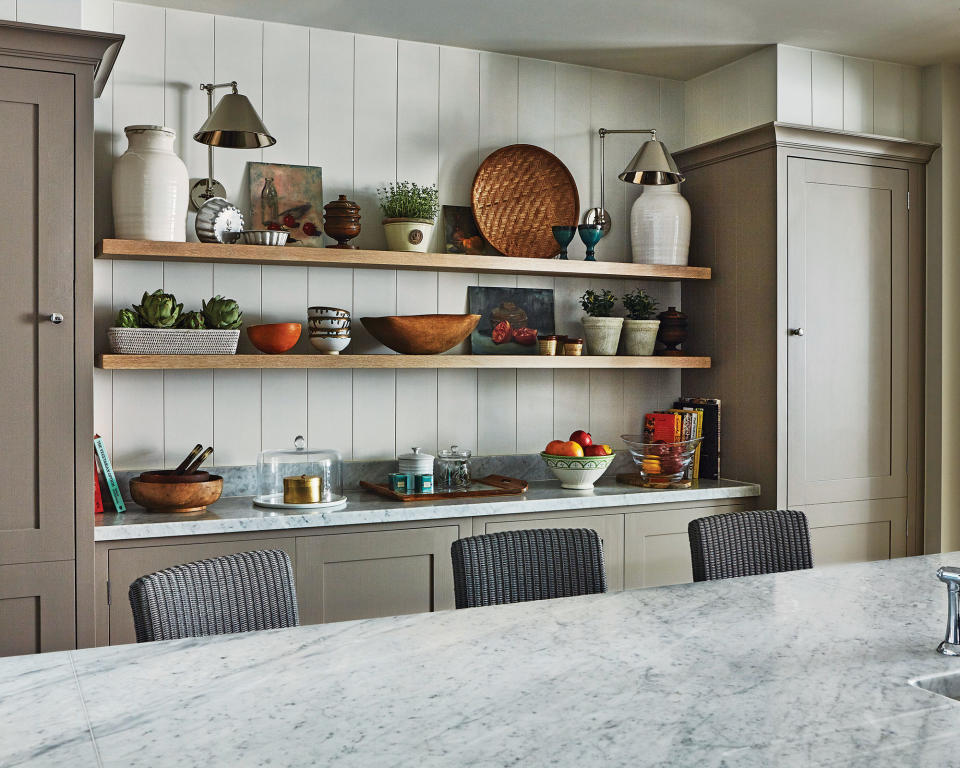 An example of kitchen storage ideas showing open shelving storing crockery, books and lamps in between kitchen cabinets