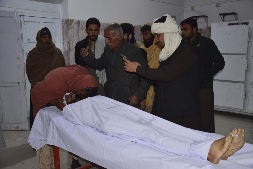 A man mourns beside the body of his family member, a victims of Afghan forces shelling, at a hospital, in Quetta, Pakistan, Sunday, Dec. 11, 2022. Pakistan's army says deadly shelling from Afghan forces has killed some people in a border town. The violence hitting southwestern Pakistan's town of Chaman was the latest in a series of deadly incidents and attacks that have skyrocketed tensions with Afghanistan's Taliban rulers. (AP Photo/Arshad Butt)