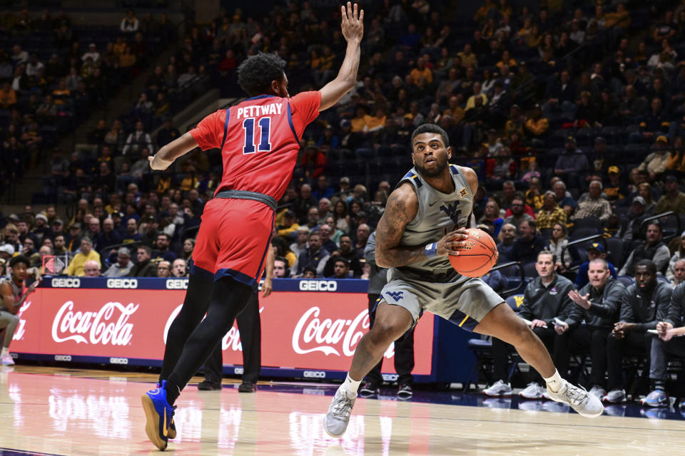 West Virginia guard Seth Wilson (14) protects the ball from Stony Brook guard Tanahj Pettway (11) during the second half of an NCAA college basketball game Thursday, Dec. 22, 2022, in Morgantown, W.Va. (William Wotring/The Dominion-Post via AP)