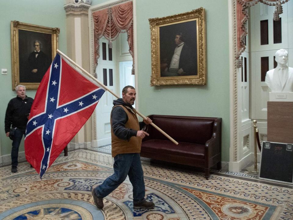 Kevin Seefried shown carrying the Confederate flag into the Capitol's rotunda on January 6, 2021.