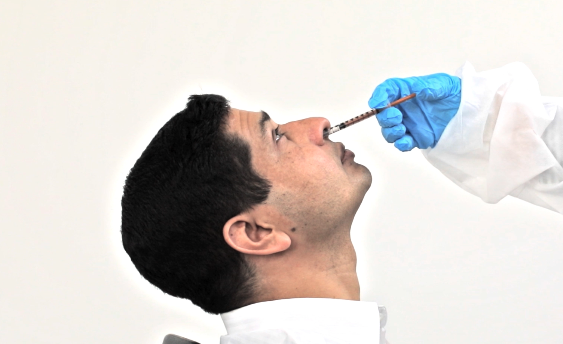 This image from a training video, shows a volunteer receiving a placebo nasal vaccine.