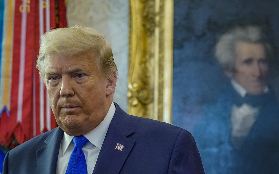 FILE - President Donald Trump in the Oval Office of the White House, during an event to award Presidential Medal of Freedom, Monday, Dec. 7, 2020, in Washington. At a hearing Friday, Dec. 3, 2021, lawyers for former President Trump argued before a federal appeals court that the U.S. government should take his place as the defendant in the lawsuit filed by columnist E. Jean Carroll, who accused him of rape. (AP Photo/Patrick Semansky, File)