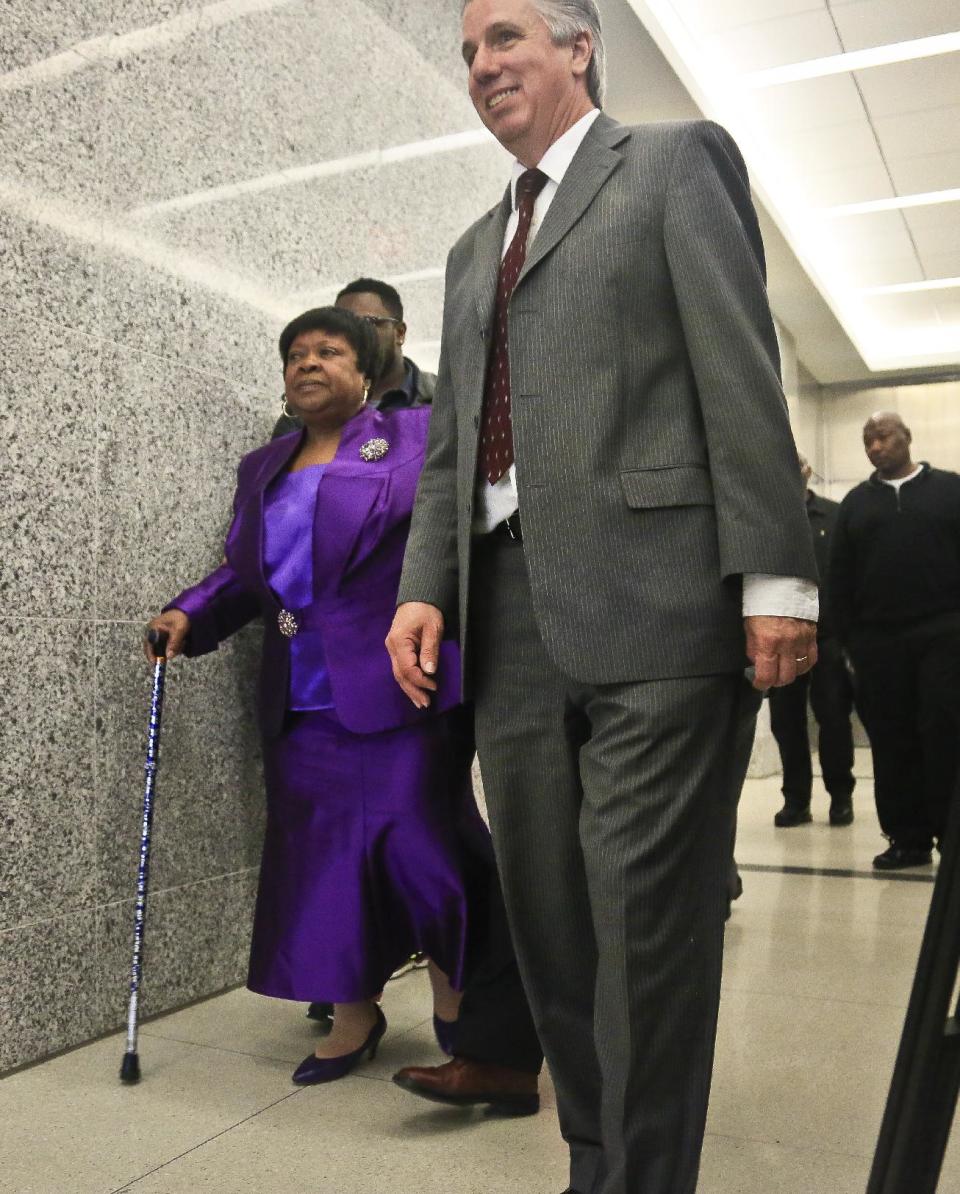 Loiuse Austin, left, is escorted to an exoneration hearing at Brooklyn Supreme Court, Tuesday May 6, 2014 in New York. Judge Neil Firetog threw out a decades-old conviction of three half-brothers Jennette, Robert Hill and Darryl Austin because of questionable tactics by the investigating homicide detective Louis Scarcella. Louise Austin stood in court for son Darryl who died in prison. (AP Photo/Bebeto Matthews)