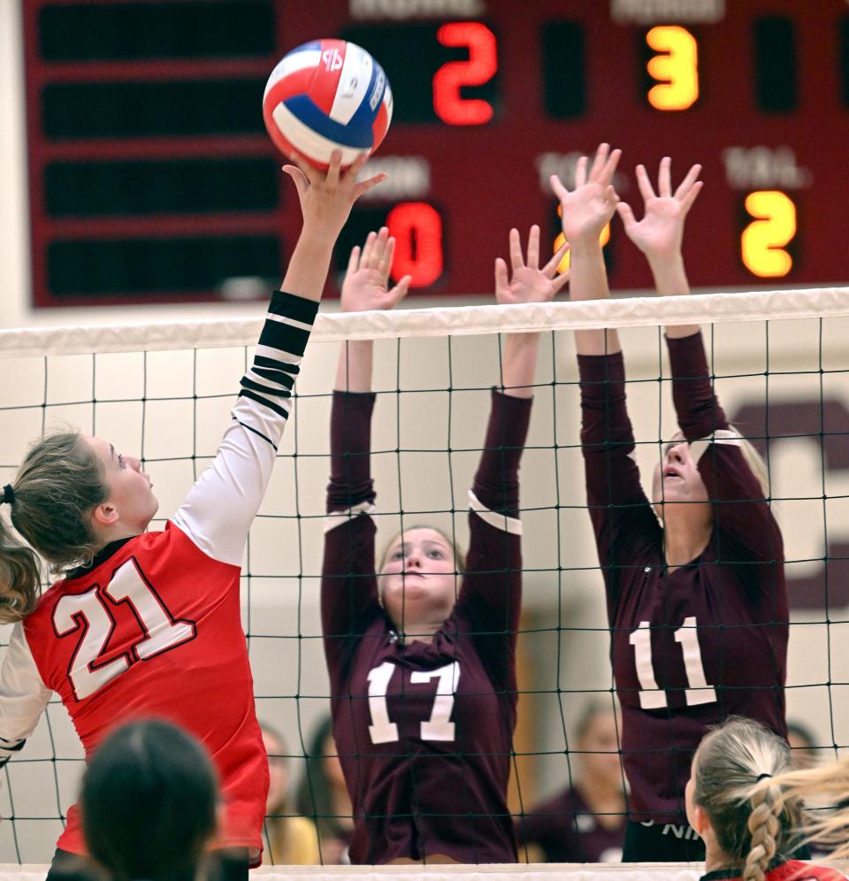 FALMOUTH   9/19/22  Molly Fredo of Barnstable pushes the ball over Chloe Rapoza (17) and Mia Cooper of Falmouth, volleyball