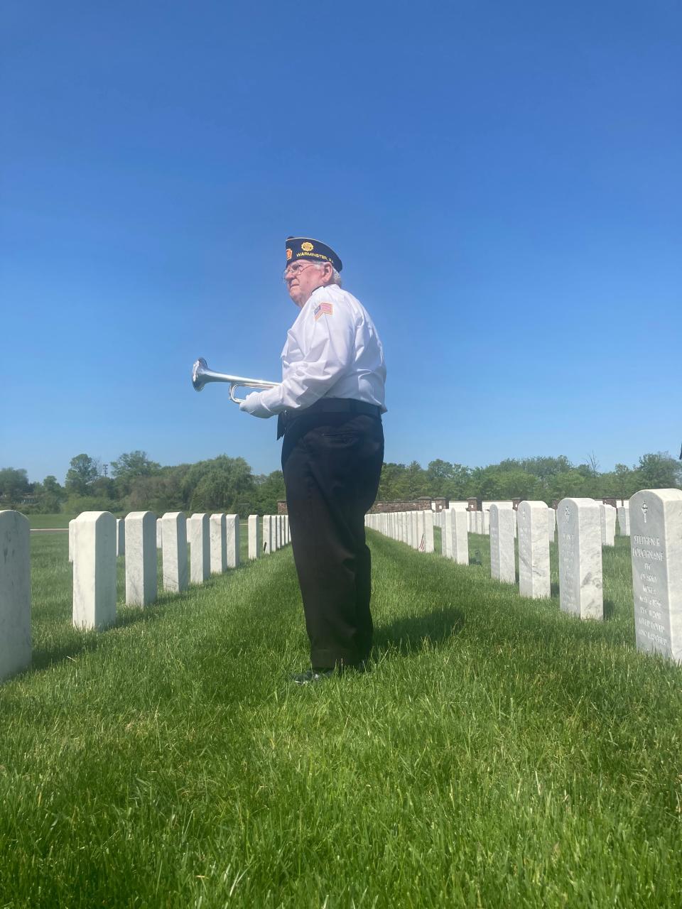 Funeral bugler Jim McDevitt, 83, of Southampton, stands amid rows of veterans' final resting place at Washington Crossing National Cemetery on Thursday, May 11, 2023. "Being part of a final goodbye to a veteran is an honor," said the Coast Guard vet.
