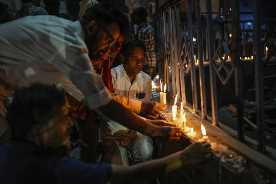 <p>People light candles to pay tribute to victims of Sunday's bridge collapse in Morbi town, in the western Indian state of Gujarat, Monday, Oct. 31, 2022. Military teams were searching Monday for people missing after a 143-year-old suspension bridge collapsed into a river Sunday in the western Indian state of Gujarat, sending hundreds plunging into the water and killing at least 133 in one of the country's worst accidents in years. (AP Photo/Rafiq Maqbool)</p> 