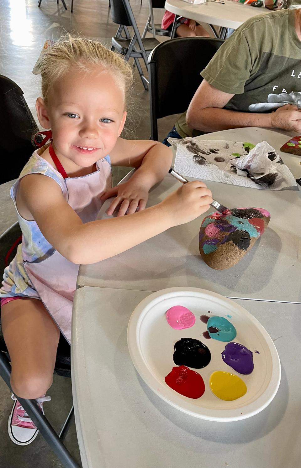 Audrey McDow paints a rock to add to the snake art in Collinsville’s South Park as a part of the “My Community, My Responsibility” program held July 11, 2023, in Collinsville, Alabama.