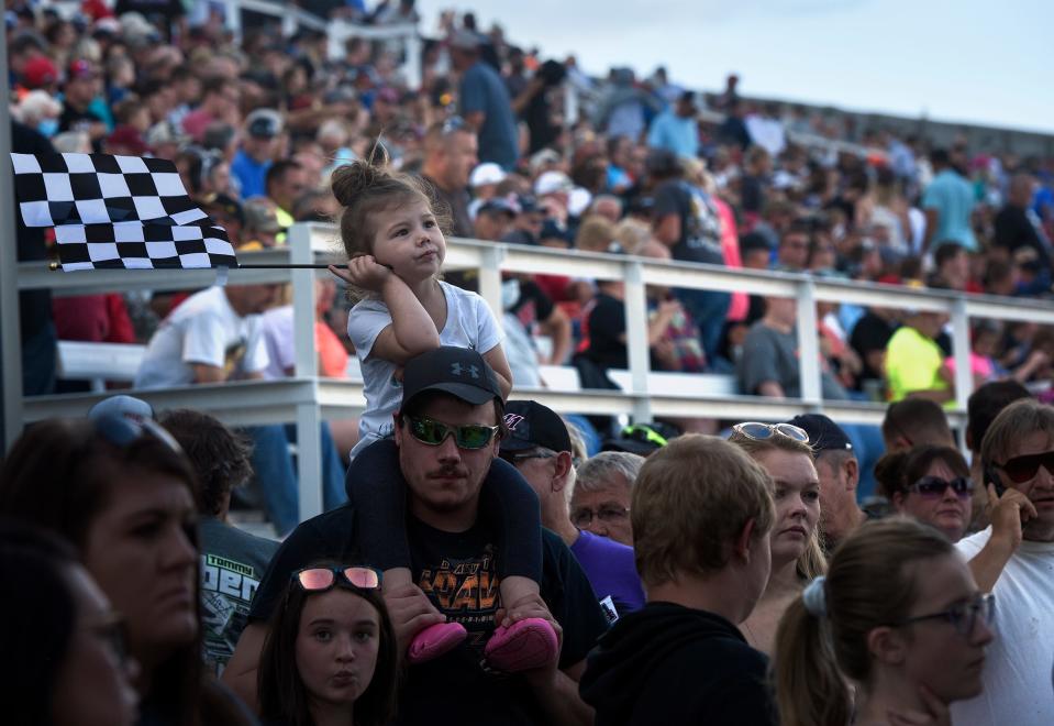 Deyvani Haeffner waits in line atop father Steven's shoulders at Huset's Speedway during its opening night Sunday in Brandon, S.D. The track had been closed since 2017.