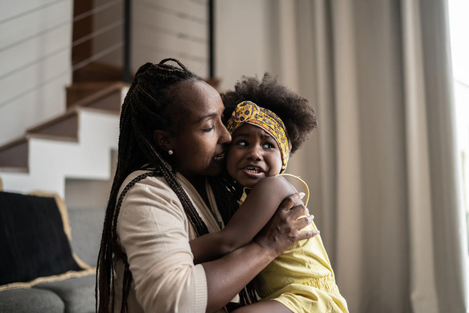 A woman holding a crying baby