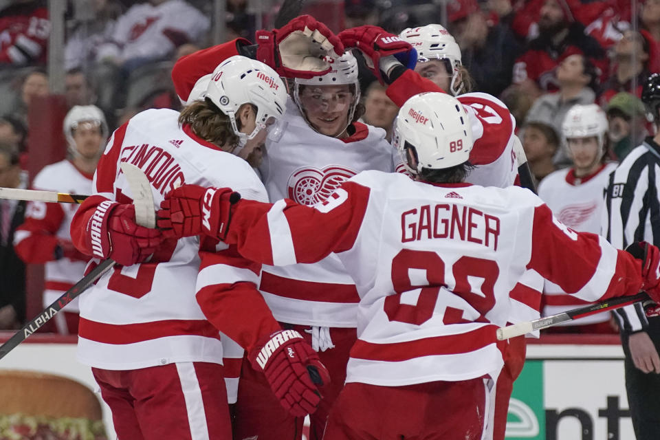 Detroit Red Wings' Moritz Seider, center, celebrates his goal with teammates during the second period of an NHL hockey game against the New Jersey Devils in Newark, N.J., Friday, April 29, 2022. (AP Photo/Seth Wenig)