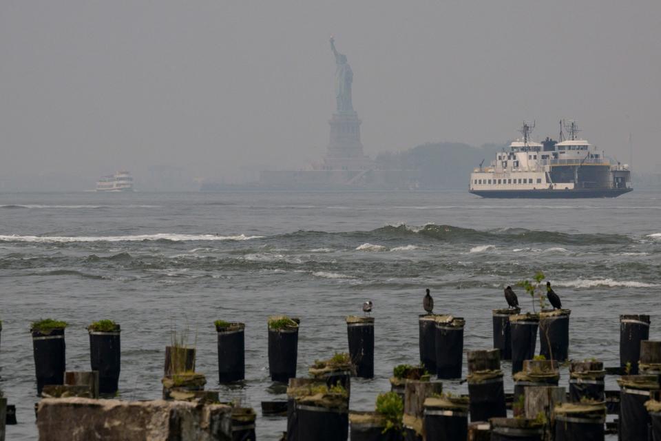 The Statue of Liberty is seen through smoke as wildfires in Canada cause hazy conditions in New York City on June 7, 2023.  / Credit: ANGELA WEISS/AFP via Getty Images