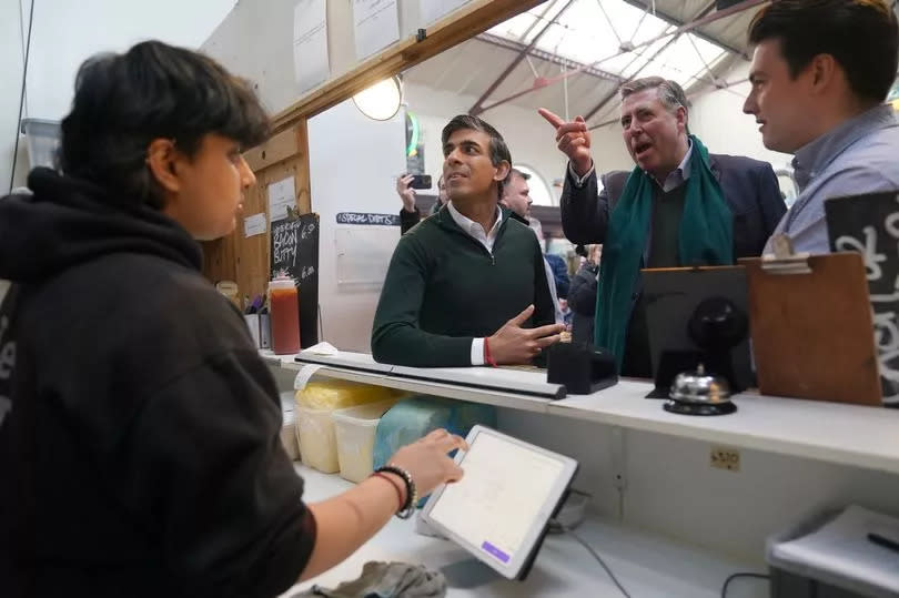 Prime Minister Rishi Sunak (second from left) and Sir Graham Brady (second from right) order food from the Great Northern Pie Company during a visit to the Altrincham Food Market