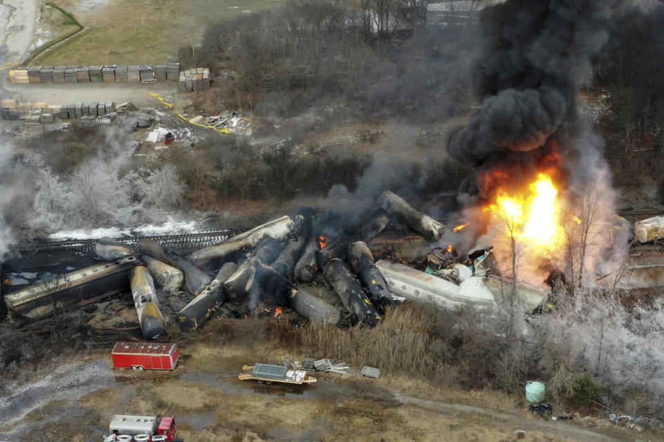 FILE - Portions of a Norfolk Southern freight train that derailed the night before burn in East Palestine, Ohio, Feb. 4, 2023. The White House says President Joe Biden will visit the eastern Ohio community that was devastated by a fiery train derailment in February 2023. (AP Photo/Gene J. Puskar, File)