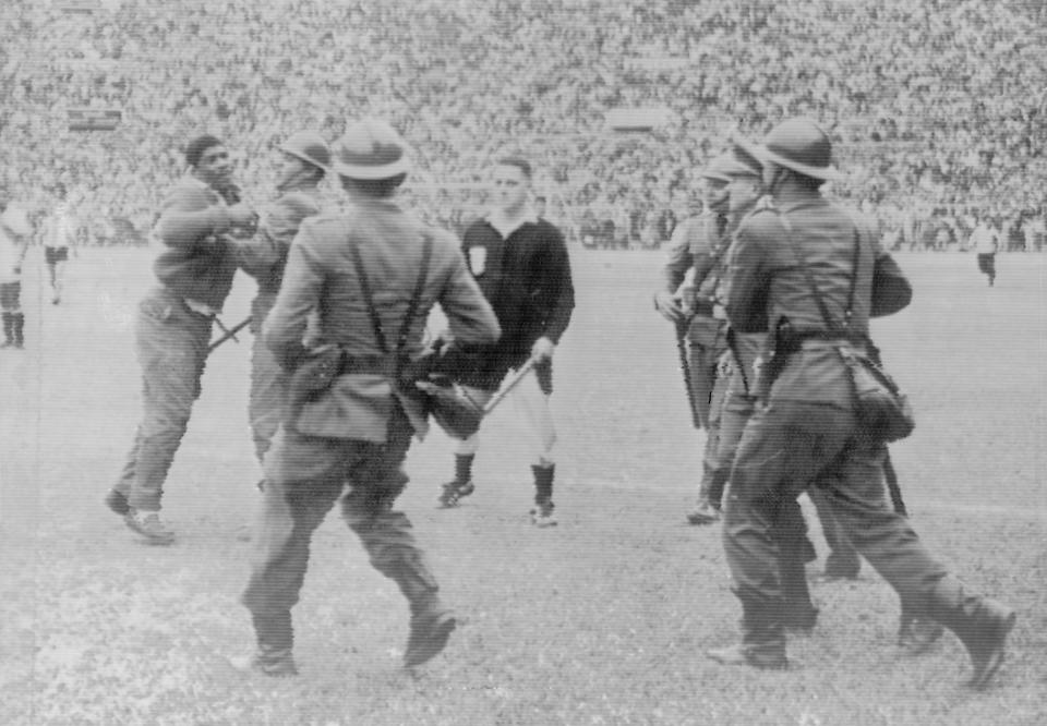 La policía retiene a un hincha enojado en la cancha del Estadio Nacional de Lima, luego de una decisión impopular de un árbitro durante un partido entre Argentina y Perú. (Getty Images)