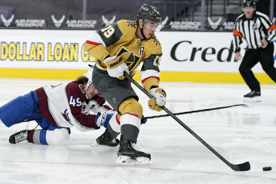 Vegas Golden Knights right wing Reilly Smith (19) shoots around Colorado Avalanche defenseman Samuel Girard (49) during the second period of an NHL hockey game Wednesday, April 28, 2021, in Las Vegas. (AP Photo/John Locher)