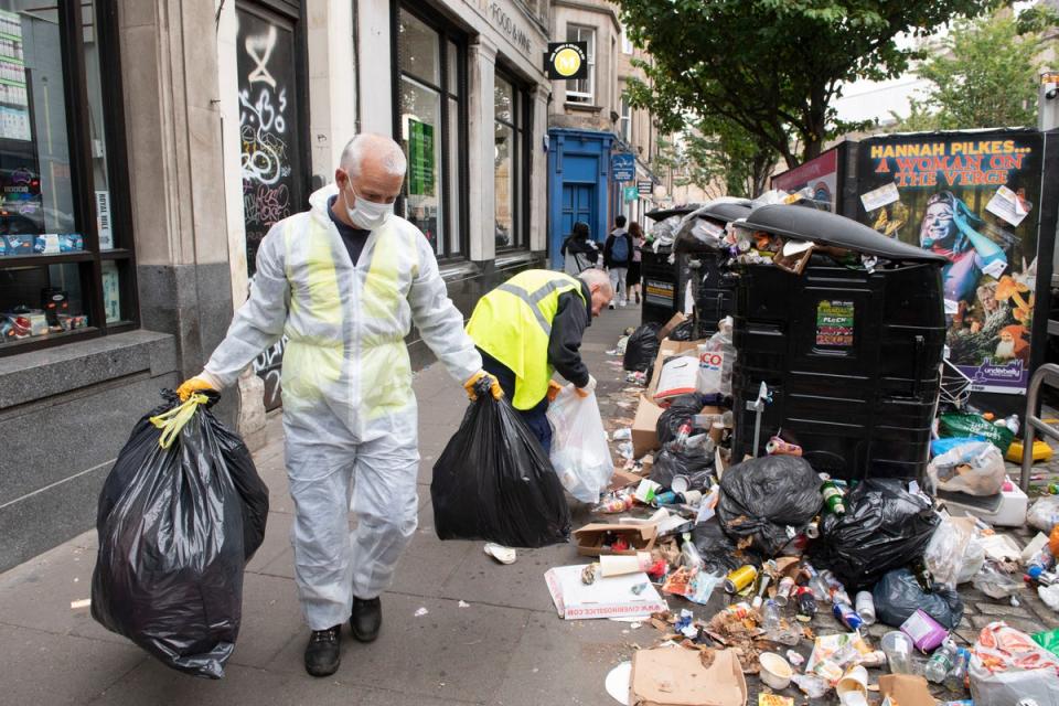 30 August 2022: Edinburgh’s waste workers clearing mountains of rubbish at Forrest Road as they return to work following their 11 days of industrial action (PA)