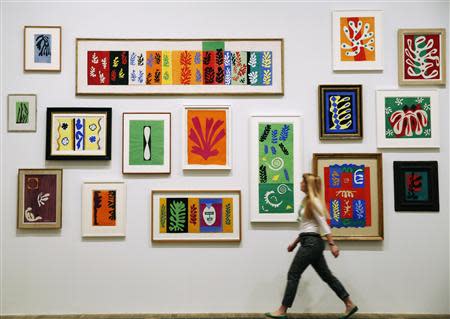 An employee poses with Henri Matisse's artworks at the Tate Modern gallery in London April 14, 2014. REUTERS/Luke MacGregor