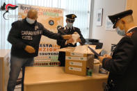 Italian Carabinieri wrap up confiscated cacti to be sent back to Chile, in Milan, Italy, Wednesday, April 7, 2021. A huge cactus bust in Italy in February 2020 resulted in the confiscation of over 1,000 rare cacti. The find became the catalyst for an international effort among cacti experts, police, conservationists and governments to launch the first rare plant return to its native habitat. (Carabinieri via AP)