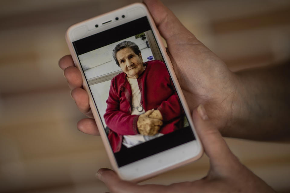 In this Wednesday, May 20, 2020 photo, Pilar Yunta Garcia shows a picture of her mother Pilar Garcia Buzon in Sevilla La Nueva, outskirts of Madrid, Spain. Pilar Garcia Buzon, 98, was one of the residents at the Usera Center for the Elderly, who died during the coronavirus outbreak in Spain. More than 19,000 coronavirus deaths in Spain's nursing homes have prompted a re-examination of a system in which public nursing homes are often controlled by private-equity firms. (AP Photo/Bernat Armangue)