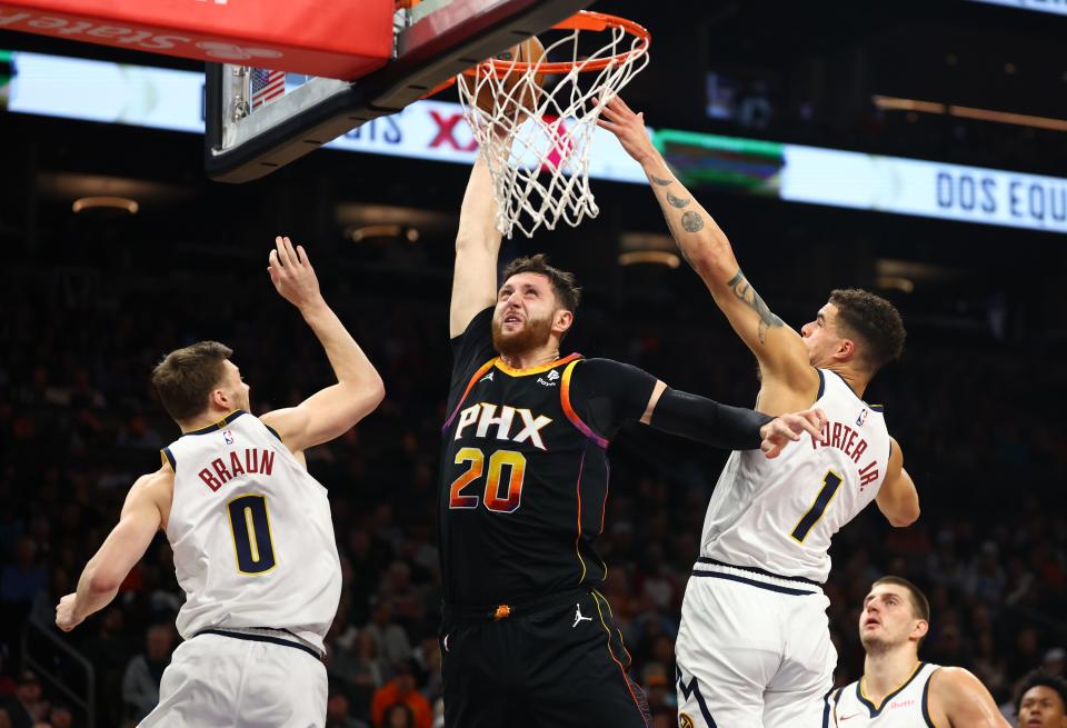 Phoenix Suns center Jusuf Nurkic (20) attempts to dunk the ball against Denver Nuggets forward Michael Porter Jr (1) and guard Christian Braun (0) in the first half at Footprint Center in Phoenix on Dec. 1, 2023.