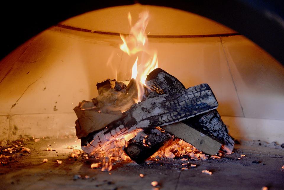 The fire burns strong inside the wood-fired oven at Cosmo's Pizza Tuesday, January 20, 2015. 