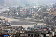 Floodwaters from the Tangjiashan quake lake flow through the earthquake-devastated city of Beichuan in Sichuan province, China, June 11, 2008. REUTERS/Jason Lee/File Photo