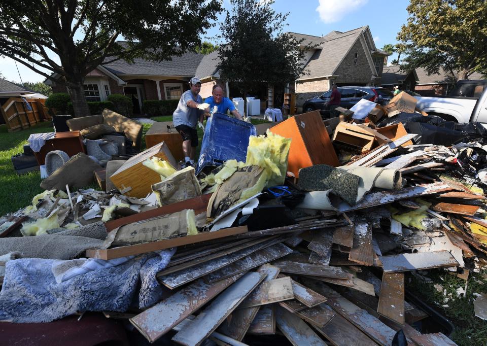 Family members remove debris and damaged items from their father's home.