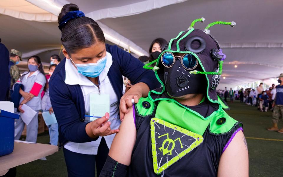 Young people - some dressed like monsters, Pikachu, Winnie the Pooh and Batman - receive their Covid-19 vaccines at the Xochimilco mayor's office in Mexico City, Mexico on 19 August 2021 - Carlos Ramirez/Shutterstock