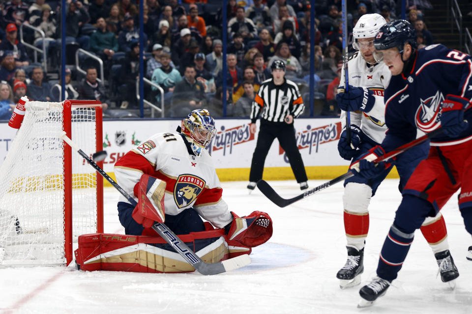 Florida Panthers goalie Anthony Stolarz, left, makes a stop in front of teammate forward Aleksander Barkov, center, and Columbus Blue Jackets forward Patrik Laine during the second period of an NHL hockey game in Columbus, Ohio, Sunday, Dec. 10, 2023. (AP Photo/Paul Vernon)