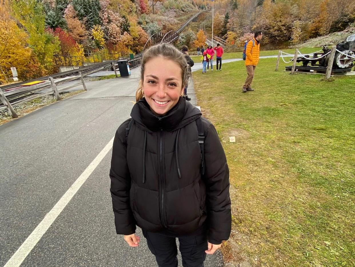 Girl smiling backdropped by autumn trees and fog