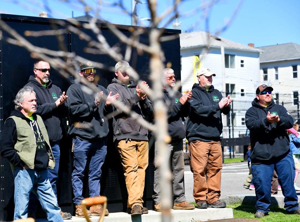 Members of the Parks, Recreation & Cemetery Department's Forestry Division stand by as city and state officials hold an Arbor Day ceremony around the two black gum trees they planted earlier at Mulcahy Field.