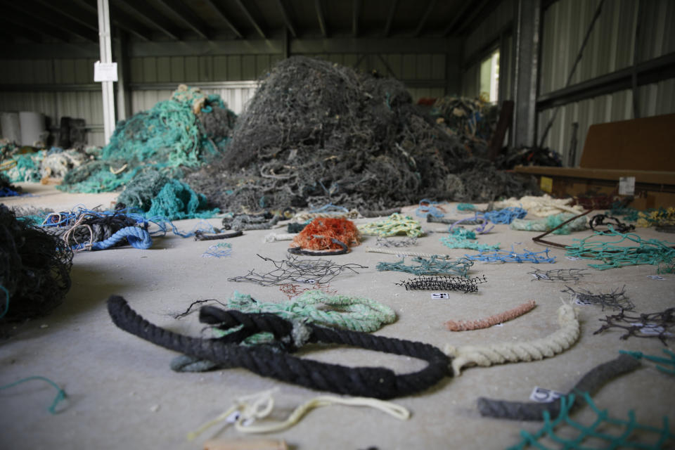 Pieces of net and other fishing gear are numbered before being cataloged at Hawaii Pacific University's Center for Marine Debris Research on Wednesday, May 12, 2021 in Kaneohe, Hawaii. The two are part of a study that is attempting to trace derelict fishing gear that washes ashore in Hawaii back to the manufacturers and fisheries that it came from. (AP Photo/Caleb Jones)