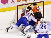 Philadelphia Flyers' Derek Grant (38) and Montreal Canadiens' Xavier Ouellet (61) crash into Canadiens goaltender Carey Price (31) during the first period of an NHL Eastern Conference Stanley Cup hockey playoff game in Toronto, Wednesday, Aug. 12, 2020. (Frank Gunn/The Canadian Press via AP)