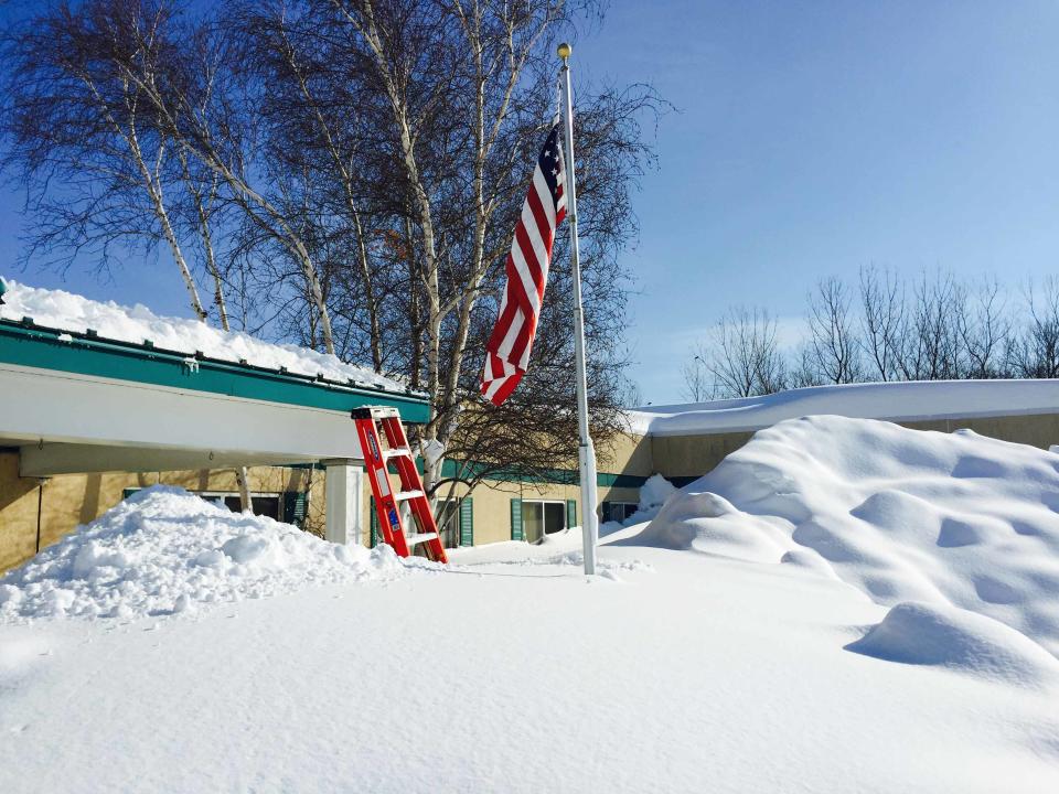 Snowdrifts reach the roof as members of New York Air National Guard assist in snow removal efforts from the roof of the Eden Heights Assisted Living Facility in West Seneca