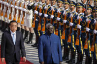 FILE - Chinese Premier Li Keqiang, left, and Solomon Islands Prime Minister Manasseh Sogavare review an honor guard during a welcome ceremony at the Great Hall of the People in Beijing, Wednesday, Oct. 9, 2019. Solomon Islands Prime Minister Sogavare has blamed foreign interference over his government's decision to switch alliances from Taiwan to Beijing for anti-government protests, arson and looting that have ravaged the capital in recent days. (AP Photo/Mark Schiefelbein, File)