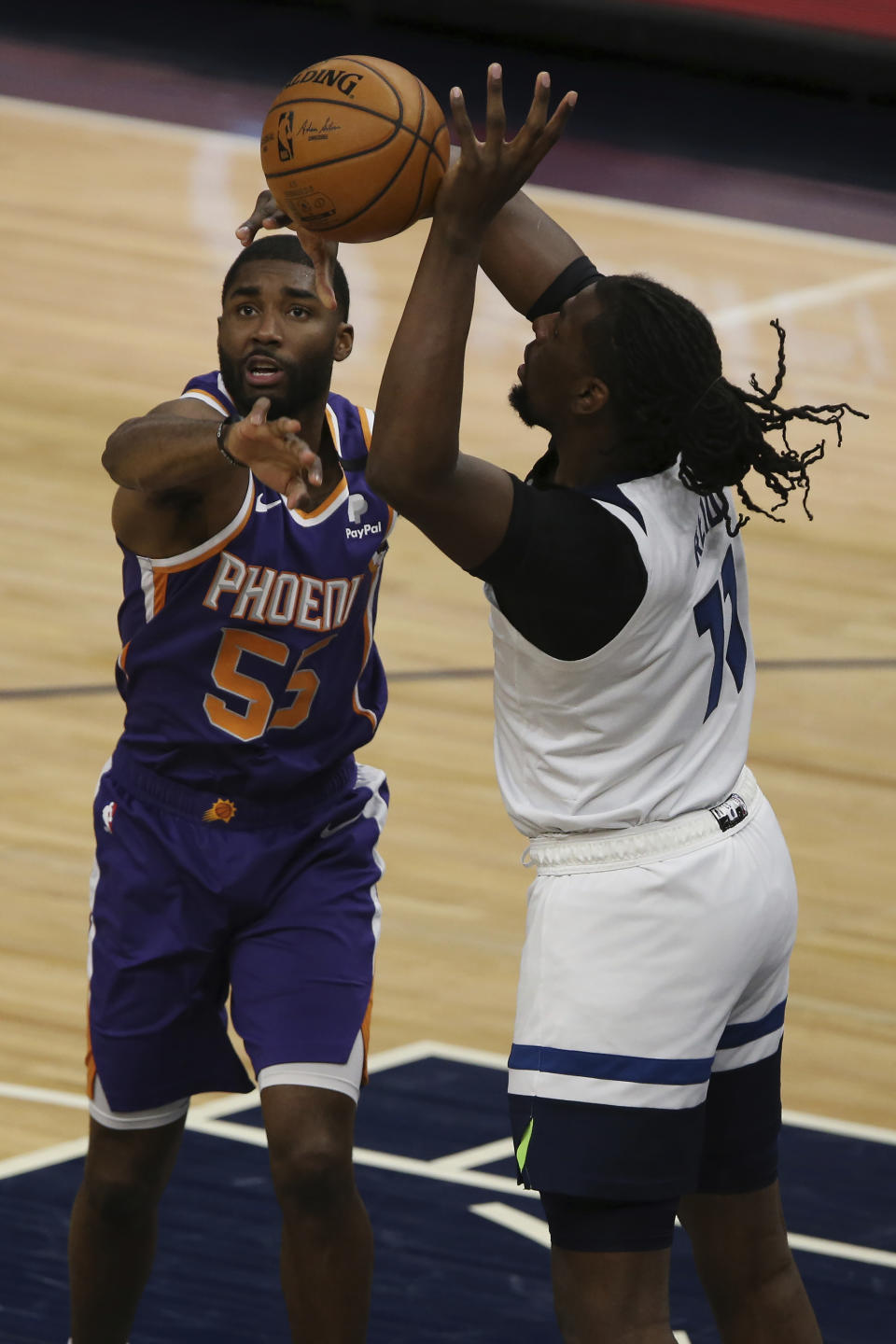 Minnesota Timberwolves's Naz Reid (11) goes after the ball against Phoenix Suns' E'Twaun Moore (55) in the first half of an NBA basketball game Sunday, Feb. 28, 2021, in Minneapolis. (AP Photo/Stacy Bengs)