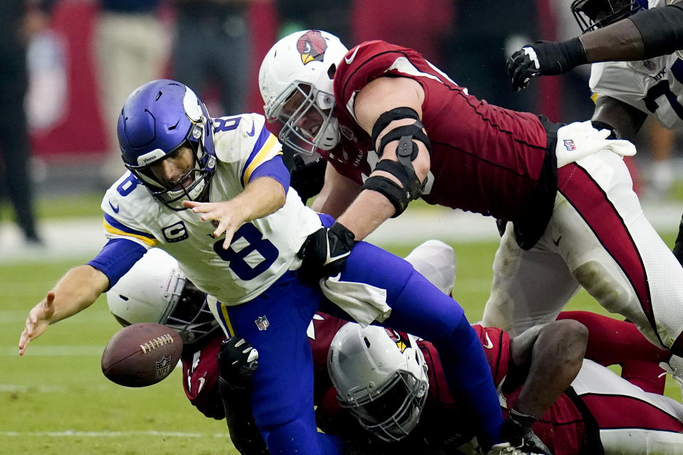 Minnesota Vikings quarterback Kirk Cousins (8) recovers his own fumble as Arizona Cardinals linebacker Markus Golden and defensive end J.J. Watt (99) make the hit during the second half of an NFL football game, Sunday, Sept. 19, 2021, in Glendale, Ariz. (AP Photo/Ross D. Franklin)