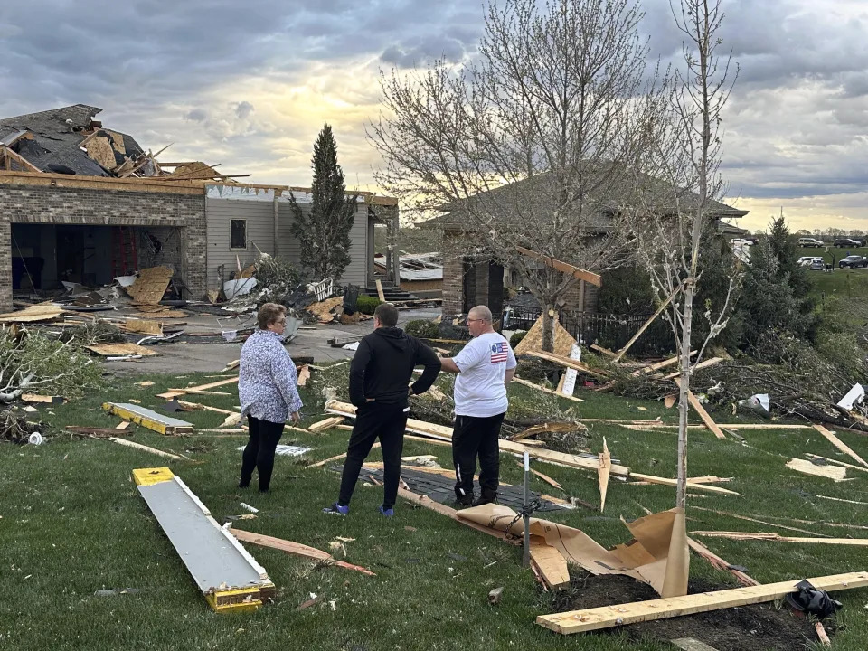 Homeowners assess damage after a tornado caused extensive damage