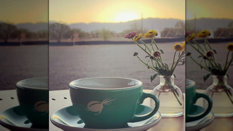 Turquoise cup next to flowers