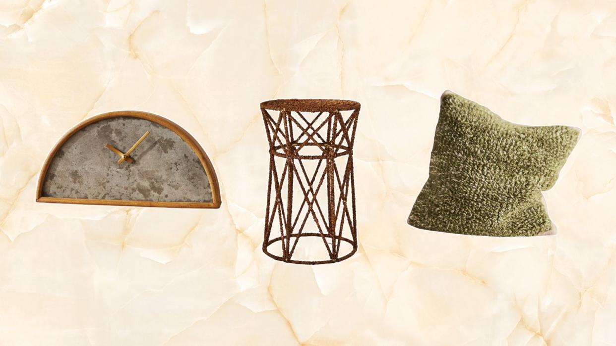  Anthropologie sale items including a rattan and concrete clock, a jute table, and a green pillow on a marble ivory background. 