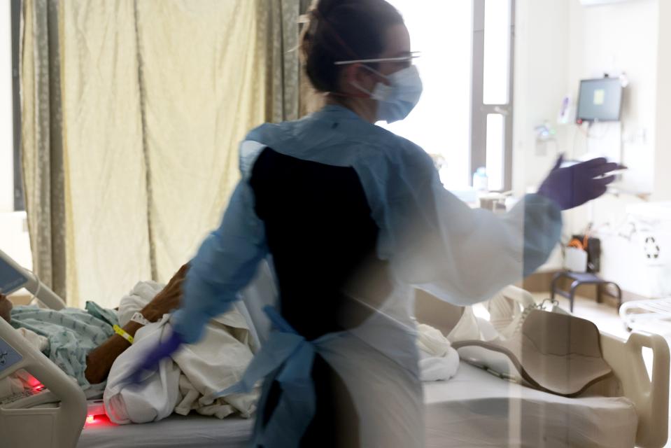 Nurse Elisa Gilbert checks on a patient in the acute care COVID-19 unit at the Harborview Medical Center on Jan. 21, 2022, in Seattle, Washington.