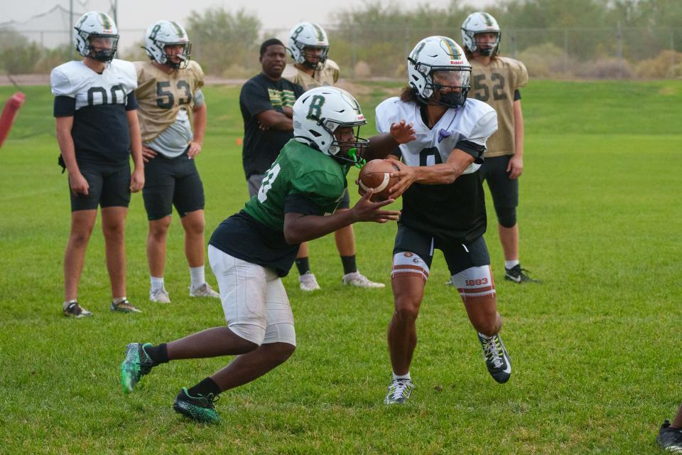 Junior quarterback, Demond Williams Jr. (front right), fakes a handoff at practice on the Basha High School practice fields on Oct. 3, 2022, in Chandler, AZ.