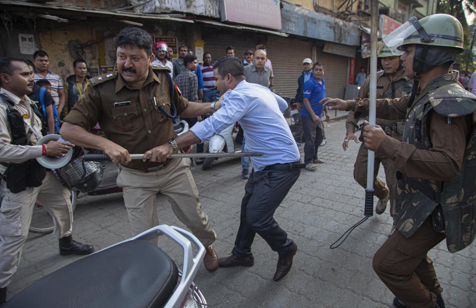 Policemen detain a protestor demonstrating against the Citizenship Amendment Bill (CAB) in Gauhati, India, Wednesday, Dec. 11, 2019. Protesters burned tires and blocked highways and rail tracks in India's remote northeast for a second day Wednesday as the upper house of Parliament began debating legislation that would grant citizenship to persecuted Hindus and other religious minorities from Pakistan, Bangladesh and Afghanistan. (AP Photo/Anupam Nath)